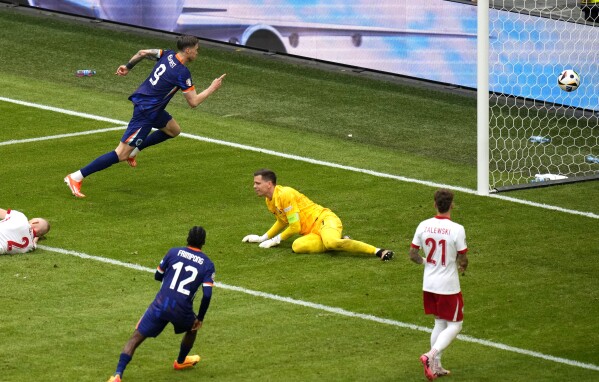 Wout Weghorst of the Netherlands, left, scores his side's second goal with his team mates during a Group D match between Poland and the Netherlands at the Euro 2024 soccer tournament in Hamburg, Germany, Sunday, June 16, 2024. (AP Photo/Petr Josek)