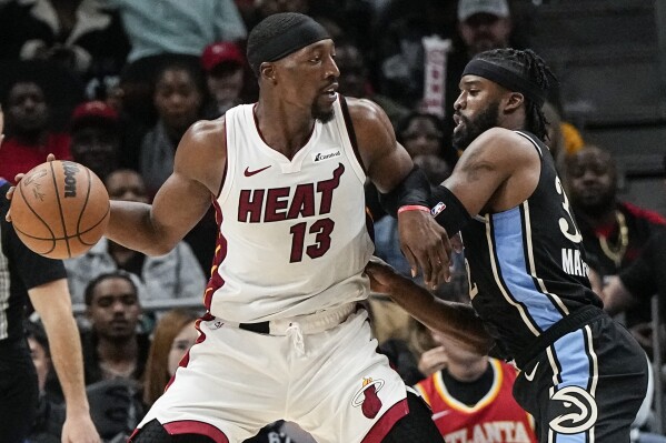 Miami Heat center Bam Adebayo (13) drives against Atlanta Hawks guard Wesley Matthews (32) during the first half of an NBA basketball game, Saturday, Nov. 11, 2023, in Atlanta. (AP Photo/Mike Stewart)