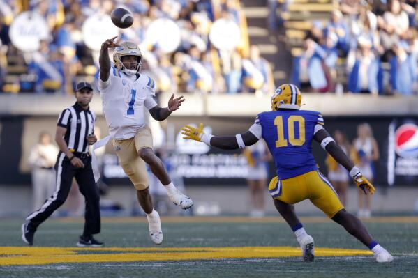 UCLA quarterback Dorian Thompson-Robinson (1) throws a pass as California linebacker Oluwafemi Oladejo (10) defends during the first half of an NCAA college football game in Berkeley, Calif., Friday, Nov. 25, 2022. (AP Photo/Jed Jacobsohn)