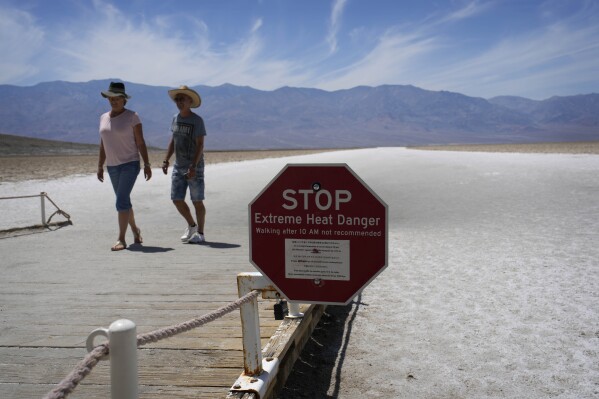FILE - A sign warns visitors of extreme heat danger at Badwater Basin, Sunday, July 16, 2023, in Death Valley National Park, Calif. A Southern California outdoor enthusiast has died after collapsing during a hike in Death Valley amid blistering heat. The Los Angeles Times reported Friday, July 21 that 71-year-old Steve Curry of Sunland, Calif., collapsed Tuesday during an hours-long hike from Golden Canyon to Zabriskie Point and died of what officials believe were heat-related causes. (AP Photo/John Locher, File)