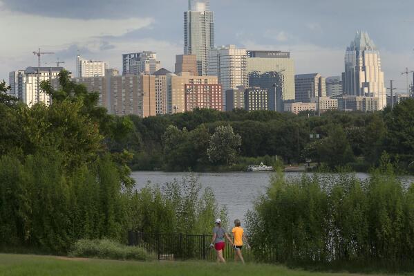 FILE - Women walk through the Lakeshore area of Austin, Texas, with the skyline in the background on Aug. 31, 2016. The Texas capital became the largest U.S. city to challenge its 2020 census figures by filing an appeal with the Census Bureau in May 2022, saying that it has more than the 961,855 residents counted during the nation's once-a-decade head count. (Ralph Barrera/Austin American-Statesman via AP, File)