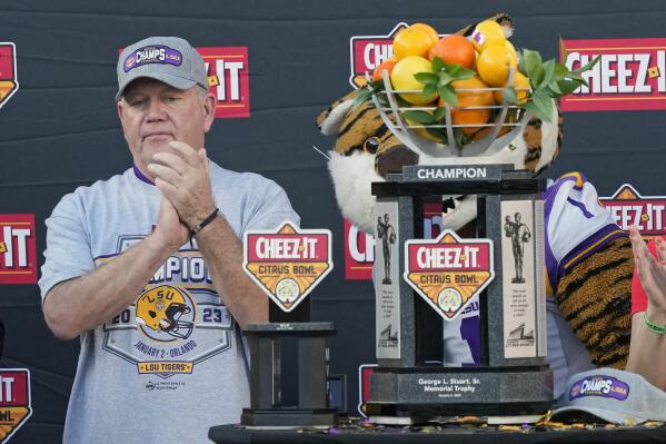 LSU head coach Brian Kelly applauds his players as he receives the championship trophy after the Citrus Bowl NCAA college football game against Purdue, Monday, Jan. 2, 2023, in Orlando, Fla. (AP Photo/John Raoux)