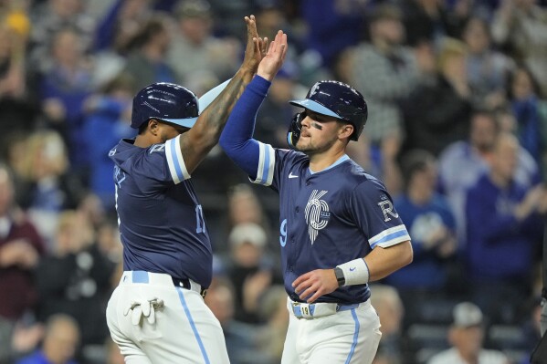 Kansas City Royals' Nelson Velazquez, left, and Michael Massey celebrate after scoring on a double hit by Hunter Renfroe during the sixth inning of a baseball game against the Baltimore Orioles Friday, April 19, 2024, in Kansas City, Mo. (AP Photo/Charlie Riedel)