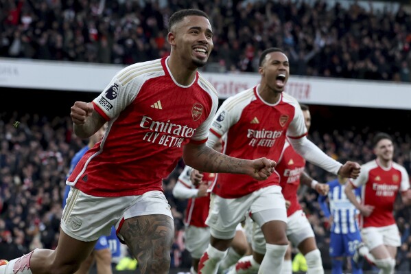 Arsenal's Gabriel Jesus, left, celebrates after scoring the opening goal during the English Premier League soccer match between Arsenal and Brighton and Hove Albion at the Emirates Stadium in London, Sunday, Dec. 17, 2023. (AP Photo/Ian Walton)
