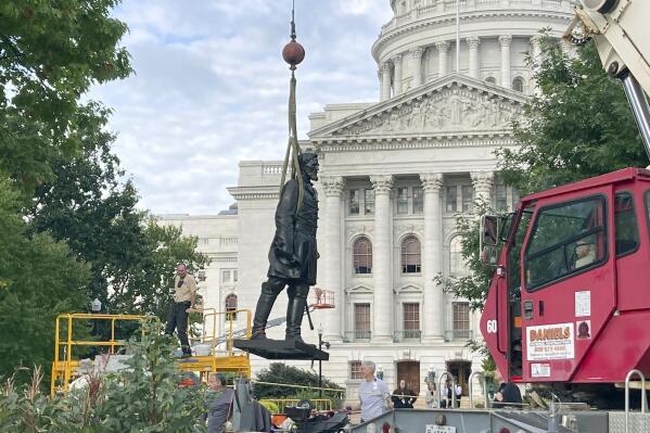 Workers reinstall a statue of Wisconsin abolitionist Col. Hans Christian Heg outside the state Capitol in Madison, Wis., on Tuesday, Sept. 21, 2021. Protesters tore the 9-foot-6-inch statue down and ripped its head off in June 2020 during a demonstration over George Floyd's death in Minneapolis. (AP Photo/Todd Richmond)