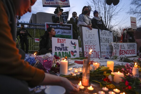 Demonstrators light candles during a vigil outside the Israeli Embassy, Monday, Feb. 26, 2024, in Washington. An active-duty member of the U.S. Air Force died after he set himself ablaze outside the Israeli Embassy in Washington, while declaring that he "will no longer be complicit in genocide." (AP Photo/Mark Schiefelbein)