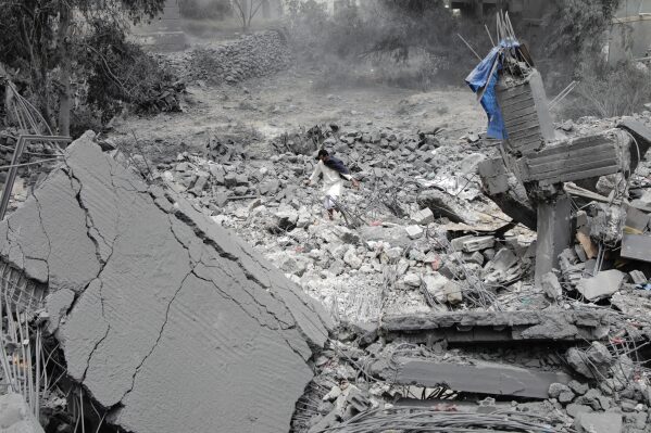 A Yemeni walks over the debris of a destroyed building after U.S. airstrikes in Sanaa, Yemen, Monday, March 24, 2025. (AP Photo)