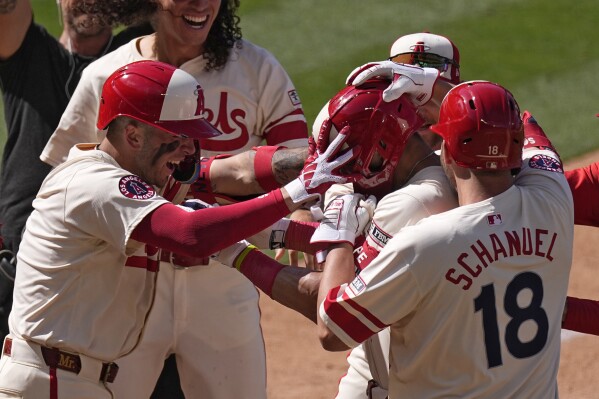 Los Angeles Angels' Logan O'Hoppe, second from right, is swarmed by teammates has after he hit a walk-off two-run home run in the ninth inning of a baseball game against the Houston Astros Sunday, June 9, 2024, in Anaheim, Calif. (AP Photo/Mark J. Terrill)
