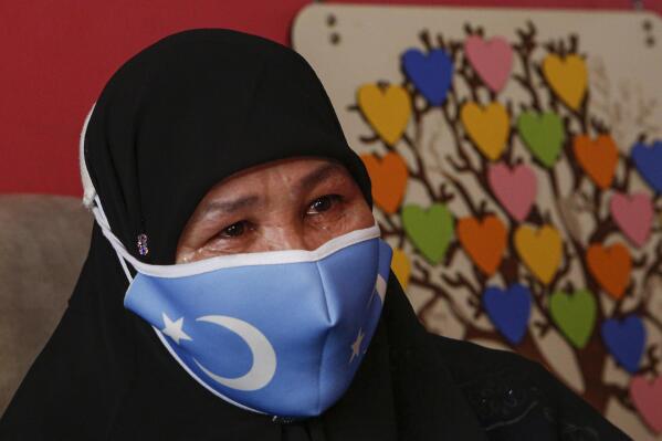 Bumeryem Rozi, 55, an ethnic Uyghur who fled from China to Turkey, cries as she talks to The Associated Press, at her home, in Istanbul, Tuesday, June 1, 2021. Rozi, a mother of four, is one of three Uyghurs who described forced abortions and torture by Chinese authorities in China's far western Xinjiang region, ahead of giving testimony to a people's tribunal in London, which is investigating if Beijing's actions against the Uyghur ethnic group amount to genocide. Rozi, said authorities in Xinjiang rounded her up along with other pregnant women to abort her fifth child in 2007. "I was 6.5 months pregnant. (AP Photo/Mehmet Guzel)