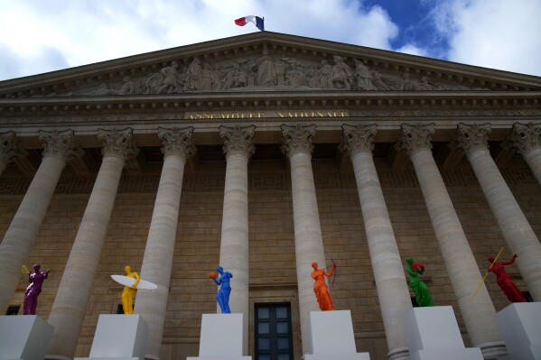 Copies of one of the most famous Greek statues, Venus Milo, are installed on the steps of the French National Assembly in Paris, France, on Monday, April 15, 2024, to celebrate the Olympic Spirit. The flower, by the artist Laurent Perbus, recovered its arms, and is now equipped with the features of six sports. (AP Photo/Christophe Ena)