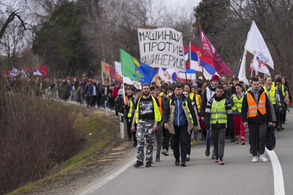 Students march trough the fields near the village of Cumic near the Serbian industrial town of Kragujevac, to protest the deaths of 15 people killed in the November collapse of a train station canopy, Friday, Feb. 14, 2025. (AP Photo/Darko Vojinovic)