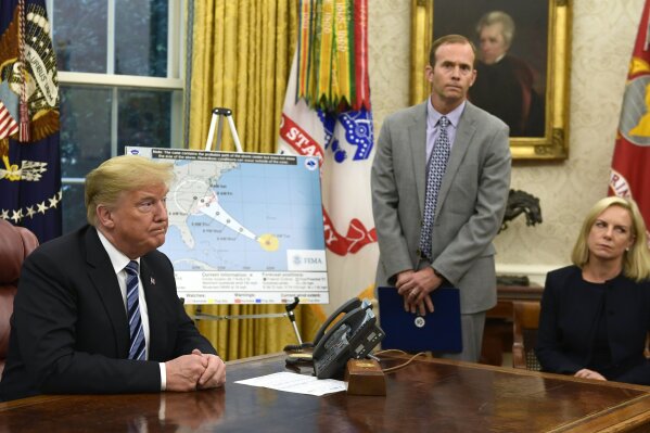 
              President Donald Trump, left, listens to a reporters question as FEMA Administrator Brock Long, center, and Homeland Security Secretary Kirstjen Nielsen, right, listen during a briefing on Hurricane Florence in the Oval Office of the White House in Washington, Tuesday, Sept. 11, 2018. (AP Photo/Susan Walsh)
            