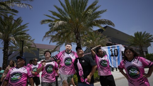 A group of South Florida fans waits outside DRV Pink Stadium, home of Inter Miami MLS soccer club, in hopes of catching a glimpse of Argentine soccer superstar Lionel Messi, Tuesday, July 11, 2023, in Fort Lauderdale, Fla. Inter Miami has announced plans to present Messi along with other new players at an event on July 16. (AP Photo/Rebecca Blackwell)