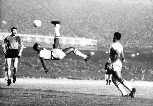FILE - In this Sept. 1968 file photo, Brazil's Pele kicks the ball during a friendly soccer game against Belgium in Rio de Janeiro, Brazil. On Oct. 23, 2020, the three-time World Cup winner Pelé turns 80 without a proper celebration amid the COVID-19 pandemic as he quarantines in his mansion in the beachfront city of Guarujá, where he has lived since the start of the pandemic.  (AP Photo, File)