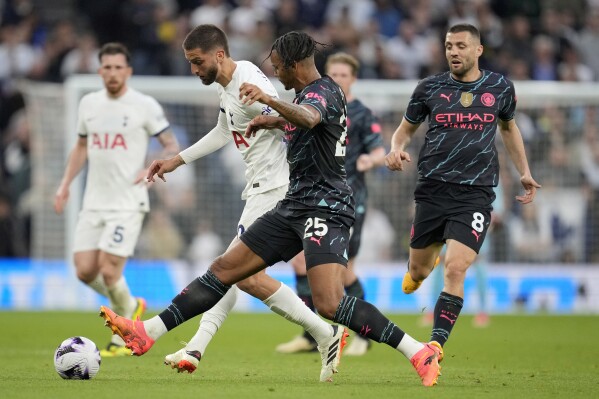 Tottenham's Rodrigo Bentancur, second left, and =Manchester City's Manuel Akanji challenge for the ball during the English Premier League soccer match between Tottenham Hotspur and Manchester City at Tottenham Hotspur Stadium in London, Tuesday, May 14, 2024.(Ǻ Photo/Kin Cheung)