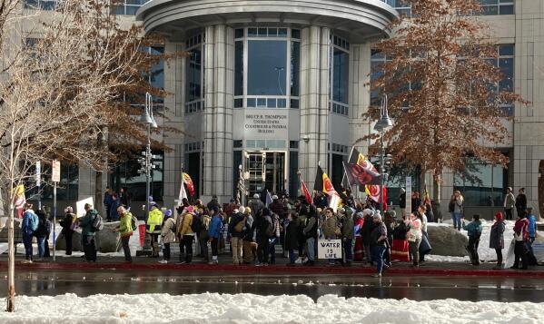FILE - Dozens of tribe members and other protesters beating drums and waving signs rally in front of the federal courthouse in Reno, Nev., Jan. 5, 2023, as a court hearing began over a lawsuit seeking to block a huge lithium mine planned near the Nevada-Oregon line about 200 miles north of Reno. On Wednesday, March 1, a federal appeals court cleared the way for construction in Nevada of the largest lithium mine in the U.S. while it considers claims by conservationists and tribes that the government illegally approved it in a rush to produce raw materials for electric vehicle batteries. (AP Photo/Scott Sonner, File)