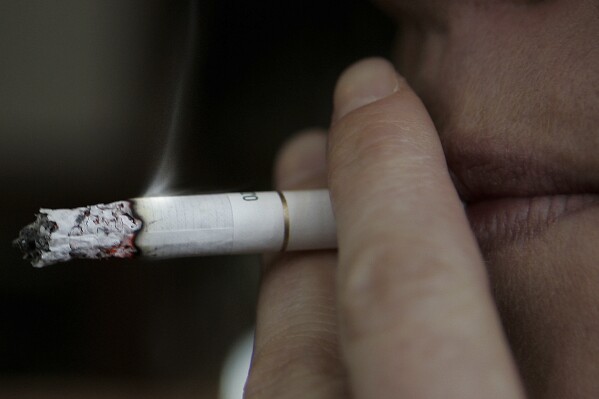 FILE - A smoker in a pub in London, Wednesday Feb. 14, 2006. British Prime Minister Rishi Sunak has proposed raising the legal age that people in England can buy cigarettes by one year, every year until it applies to the whole population. Sunak said the planned change will mean that “a 14-year-old today will never legally be sold a cigarette.