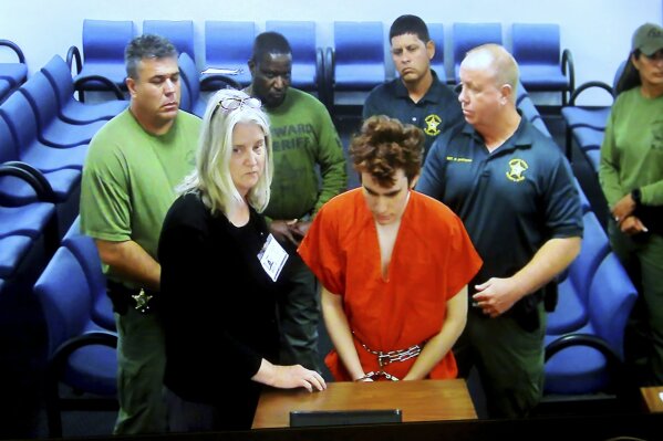 
              Florida school shooting suspect Nikolas Cruz appears in court via video with public defender Diane Cuddihy in Fort Lauderdale, Fla., Wednesday, Nov. 14, 2018. Cruz attacked a detention officer at the county jail and now faces new charges including use of the officer's electric stun device, authorities said Wednesday. (Mike Stocker/South Florida Sun-Sentinel via AP)
            