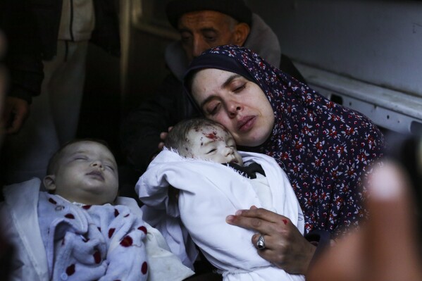 Rania Abu Anza cradles her twins, who were killed in an Israel strike on a house in Rafah, in the southern Gaza Strip, Sunday, March 3, 2024. Abu Anza and her husband, who was killed in the same strike, spent 10 years trying to get pregnant. (AP Photo/Hatem Ali)