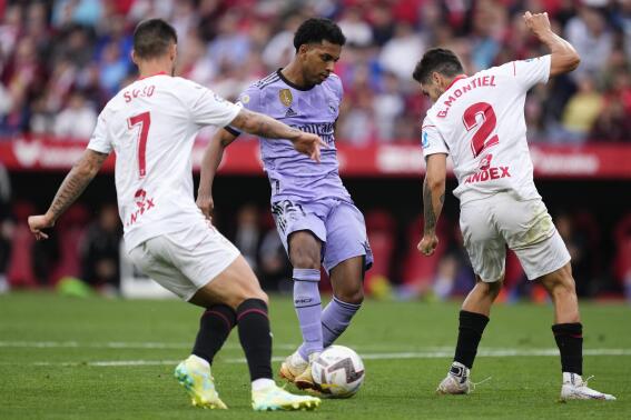 Real Madrid's Rodrygo, centre, shoots to score his side's second goal during a Spanish La Liga soccer match between Sevilla and Real Madrid at the Ramon Sanchez Pizjuan stadium in Seville, Spain, Saturday, May 27, 2023. (AP Photo/Jose Breton)