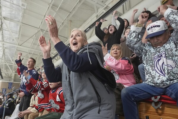Julie Brian, center, of Layton, Utah, celebrates as the Ogden Mustangs score against the Utah Outliers during the Mountain Division Championship game Wednesday, April 17, 2024, in West Valley City, Utah. It may look like an NHL team has just fallen into Salt Lake City's lap. But local organizers say the Arizona Coyotes' relocation to Utah is the product of a yearslong effort to beckon professional hockey and other elite sports to the capital city. (AP Photo/Rick Bowmer)