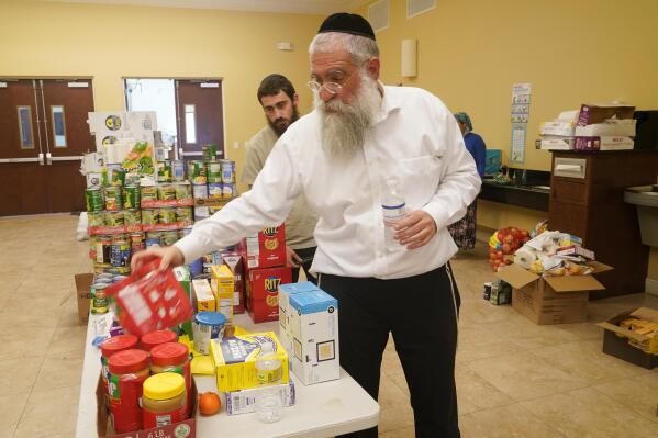 Rabbi Yitzchok Minkowicz supervises the pantry inside the Chabad Lubavitch of Southwest Florida, Monday, Oct. 3, 2022, in Fort Myers, Fla. The synagogue has been transformed into a full-fledged community center with food trucks and a pantry. They plan on celebrating Yom Kippur on Tuesday. (AP Photo/Marta Lavandier)