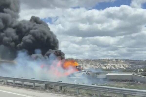 This frame grab taken from video provided by Bryan Wilson, shows a freight train carrying fuel that derailed and caught fire, Friday, April 26, 2024, near the New Mexico-Arizona state line, east of Lupton, Ariz. Authorities closed Interstate 40 in both directions in the area, directing trucks and motorists to alternate routes. (Bryan Wilson via AP)