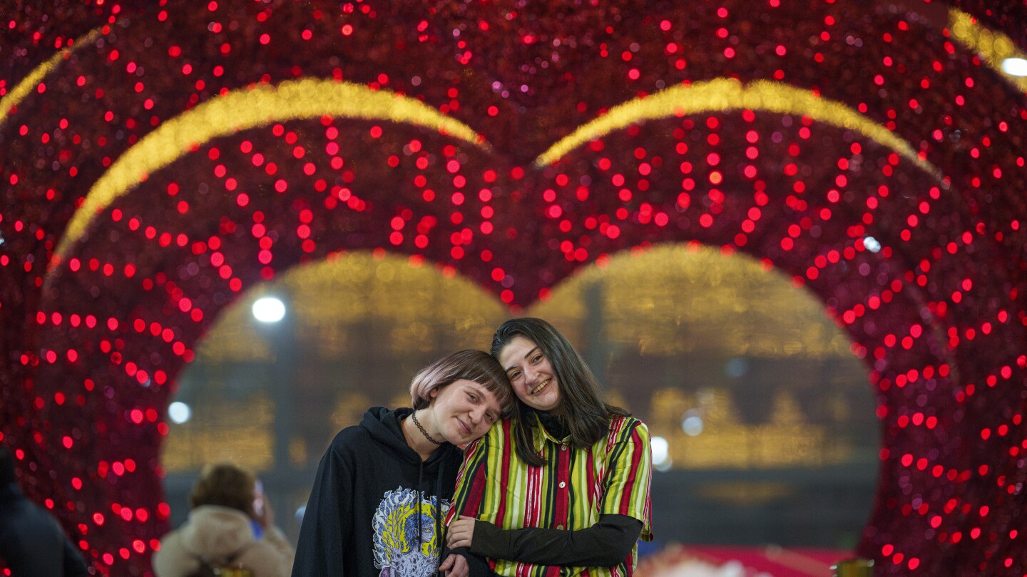 A couple waits for their turn in a mock marriage ceremony dubbed "Married for one day" during a Valentine's Day event in Bucharest, Romania, Tuesday, Feb. 13, 2024. (AP Photo/Andreea Alexandru)