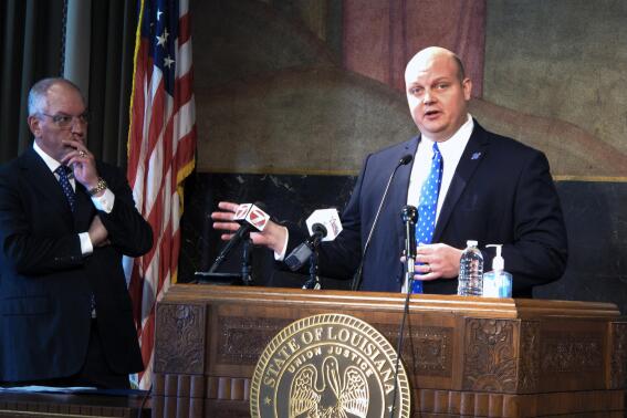 Lake Charles Mayor Nic Hunter speaks about plans for $11.3 million in housing rebuilding programs for his city, which is struggling to recover from the back-to-back blows of Hurricanes Laura and Delta, while Louisiana Gov. John Bel Edwards listens, on Monday, Nov. 22, 2021, in Baton Rouge, La. (AP Photo/Melinda Deslatte)