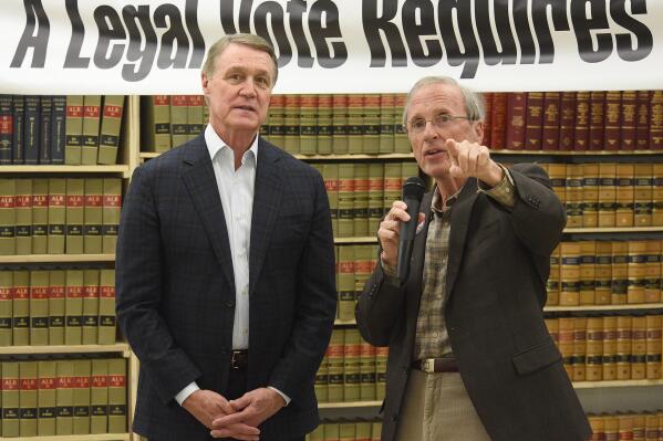 Former U.S. Sen. David Perdue, left, and Garland Favorito talk at the northwest Georgia headquarters for Voters Organized for Trusted Election Results in Georgia, in Ringgold, Ga., Thursday, April 14, 2022. Perdue is building his campaign around former President Donald Trump and veering to the right as he tries to unseat Republican Gov. Brian Kemp in a May 24 GOP primary. (Matt Hamilton/Chattanooga Times Free Press via AP)