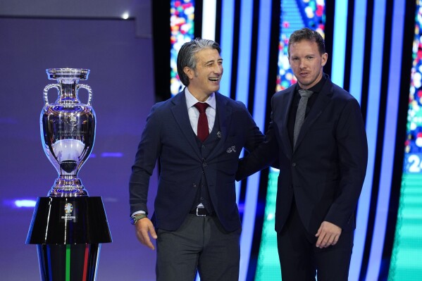 FILE - The head coaches of Switzerland Murat Yakin, left,and Germany Julian Nagelsmann, right, pose next to the trophy after the draw for the UEFA Euro 2024 soccer tournament finals in Hamburg, Germany, Saturday, Dec. 2, 2023. Host nation Germany may be the heavyweight in its European Championship group, but any of Scotland, Hungary or Switzerland is capable of causing an upset in Group A. (AP Photo/Martin Meissner, File)