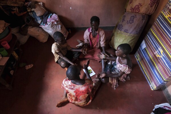 Children of Simon Tigawalana play while sitting on a clay-based earthen floor made by EarthEnable on May 16, 2025, in Jinja, Uganda. (AP Photo/Hajarah Nalwadda)