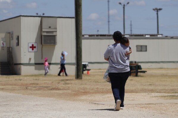 Immigrants seeking asylum walk at the ICE South Texas Family Residential Center, Aug. 23, 2019, in Dilley, Texas. (AP Photo/Eric Gay, File)