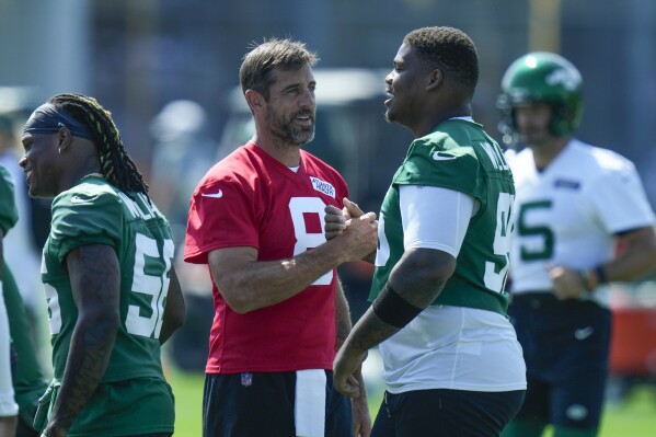 New York Jets quarterback Aaron Rodgers, left, greets Quinnen Williams at the NFL football team's training facility in Florham Park, N.J., Sunday, July 23, 2023. (AP Photo/Seth Wenig)