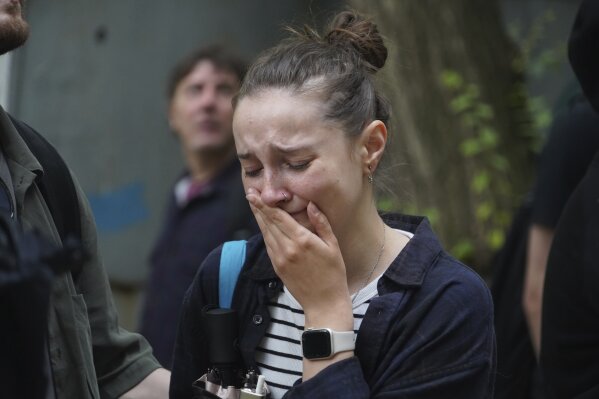 A woman reacts as she looks on a multi-storey building damaged by a Russian strike in Kharkiv, Ukraine, Saturday, June 7, 2025. (AP Photo/Andrii Marienko)