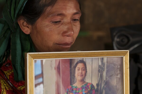 Olivia Orozco Lopez cries as she holds a portrait of her late daughter Celestina Carolina during an interview in the Culvilla hamlet of Tejutla, Guatemala, Tuesday, March 19, 2024. Carolina died asphyxiated alongside 50 other migrants in a smuggler's trailer truck in San Antonio, Texas in June 2022. (AP Photo/Moises Castillo)