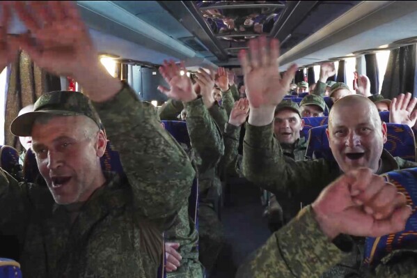 In this photo taken from video released by Russian Defense Ministry Press Service on Saturday, May 24, 2025, Russian servicemen react in a bus upon arrival to Chkalovsky airport, outside Moscow, Russia, after returning from captivity by a POWs exchange between Russia and Ukraine. (Russian Defense Ministry Press Service photo via AP)