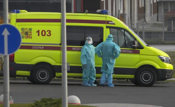 Medical workers stand near their ambulance as they deliver a patient suspected of having coronavirus to a hospital in Kommunarka, outside Moscow, Russia, Tuesday, Oct. 12, 2021. Russia hit another record of daily coronavirus deaths Tuesday as the country struggled with a rapid surge of infections and lagging vaccination rates, but authorities have been adamant that there would be no new national lockdown. (AP Photo/Alexander Zemlianichenko)