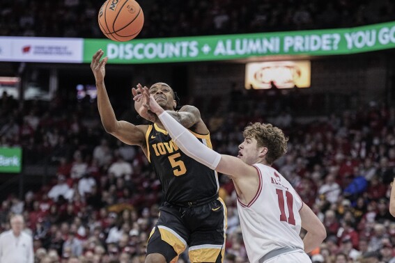 Wisconsin's Max Klesmit (11) fouls Iowa's Dasonte Bowen (5) during the first half of an NCAA college basketball game Tuesday, Jan. 2, 2024, in Madison, Wis. (AP Photo/Andy Manis)