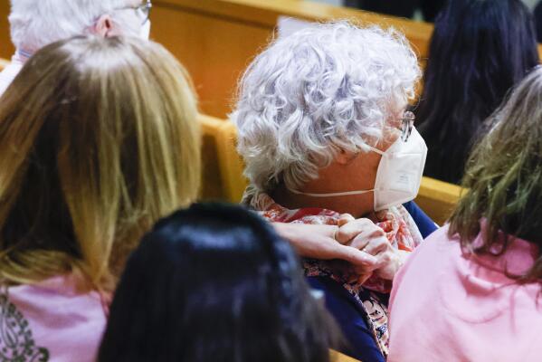 Karen Harris, right, daughter of victim Miriam Nelson, reacts as she embraces her husband Cliff Harris after Billy Chemirmir was found guilty of killing 87-year-old Mary Brooks by the members of the jury during the final day of his third court trial at Frank Crowley Courts Building in Dallas on Friday, Oct. 7, 2022. Chemirmir, 49, is charged with capital murder of 22 elderly people in North Texas. Jurors deliberated less than 30 minutes. . (Shafkat Anowar/The Dallas Morning News via AP)