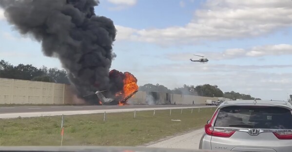 Smoke and fire fills the air after an airplane crashed on Interstate 75, Friday, Feb. 10, 2024 near Naples, Fla. Federal authorities have launched an investigation to determine why the private jet tried to make an emergency landing on the Florida interstate, colliding with a vehicle and sparking a fiery crash that left two people dead. (Chris O'Conner via 麻豆传媒app)
