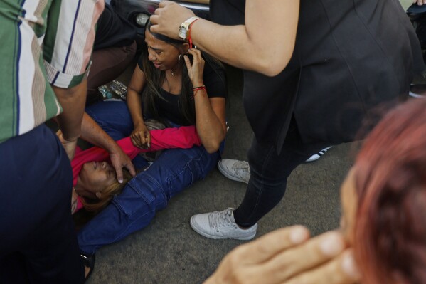 Relatives cry while waiting for news of loved ones outside the Jet Set nightclub after its roof collapsed during a merengue concert in Santo Domingo, Dominican Republic, Tuesday, April 8, 2025. (AP Photo/Eddy Vittini)