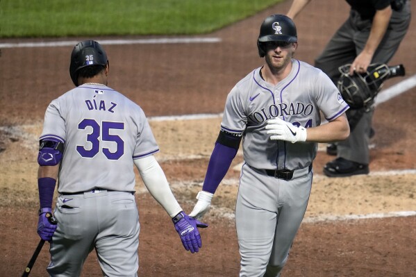 Colorado Rockies' Ryan McMahon, right, is greeted by Elias Díaz as he heads to the dugout after hitting a solo home run off Pittsburgh Pirates starting pitcher Martín Pérez during the sixth inning of a baseball game in Pittsburgh, Friday, May 3, 2024. (AP Photo/Gene J. Puskar)