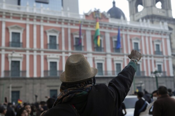 A supporter of Bolivian President Luis Arce raises a clenched fist in front of the government palace in Plaza Murillo, in La Paz, Bolivia, Wednesday, June 26, 2024. Arce addressed supporters who gathered in Plaza Murillo, after Wednesday’s apparent failed coup attempt. (AP Photo/Juan Karita)