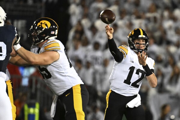 Iowa quarterback Cade McNamara (12) looks to pass against Penn State during the first half of an NCAA college football game, Saturday, Sept. 23, 2023, in State College, Pa. (AP Photo/Barry Reeger)
