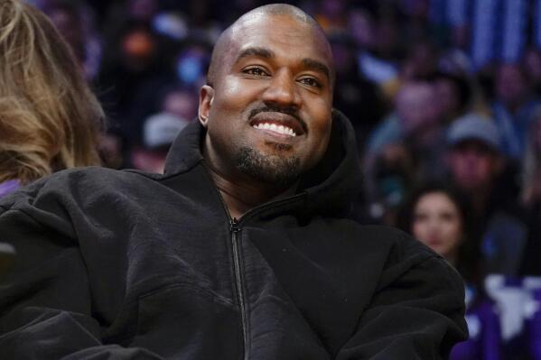 FILE - Kanye West, known as Ye, watches the first half of an NBA basketball game between the Washington Wizards and the Los Angeles Lakers in Los Angeles, March 11, 2022. Adidas is facing a class-action lawsuit from investors that was filed Friday, April 28, 2023, alleging the company knew about offensive remarks and harmful behavior from Ye years before ending its partnership with him. (AP Photo/Ashley Landis, File)