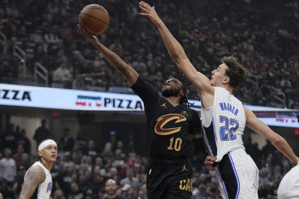 Cleveland Cavaliers guard Darius Garland (10) shoots in front of Orlando Magic forward Franz Wagner (22) in the first half of Game 7 of an NBA basketball first-round playoff series Sunday, May 5, 2024, in Cleveland. (AP Photo/Sue Ogrocki)