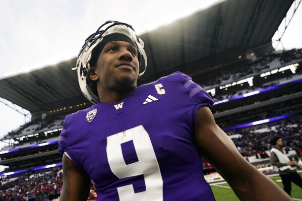 Washington quarterback Michael Penix Jr. smiles on the field following a 35-28 victory over Utah in an NCAA college football game Saturday, Nov. 11, 2023, in Seattle. (AP Photo/Lindsey Wasson)