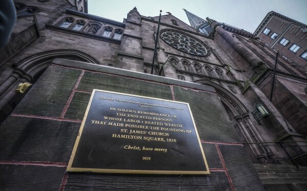 A plaque sits at the steps of St. James Episcopal Church, Friday Dec. 4, 2020, in New York's Upper East Side neighborhood, acknowledging the church's wealth created with slave labor. (AP Photo/Bebeto Matthews)