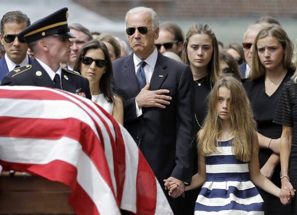 Then-Vice President Joe Biden, accompanied by his family, holds his hand over his heart as he watches an honor guard carry a casket containing the remains of his son, former Delaware Attorney General Beau Biden, into St. Anthony of Padua Roman Catholic Church in Wilmington, Del., June 6, 2015, for funeral services. (AP Photo/Patrick Semansky)